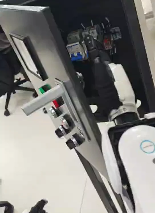 Robot gripper opening the cabinet door and revealing the internal control bank